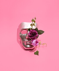Metallic human mask creatively decorated with fresh green leaves and purple roses. Natural elements combined with futuristic,  digital inspired layout.