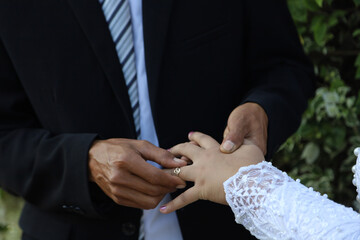 Obraz na płótnie Canvas The bride and groom put their wedding rings on the wedding ceremony. happy bride and groom