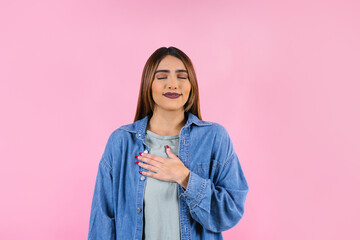 Young latin woman practicing breathing or meditating or yoga class on pink background in Mexico...