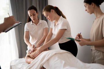 Woman teacher helping students become a masseuse, wellness massage training