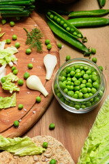 vegetables on a wooden kitchen board, green onions, dill and peas, sliced cabbage on a wood background, concept of fresh and healthy food, still life