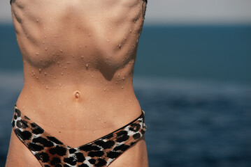 Torso of slim attractive female with flat belly in white underwear.