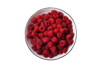 Red raspberry berry in plate on wooden table.