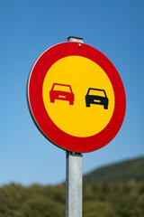 Señal vertical, de tráfico adelantamiento prohibido por obras sobre un cielo azúl (amarillo,...