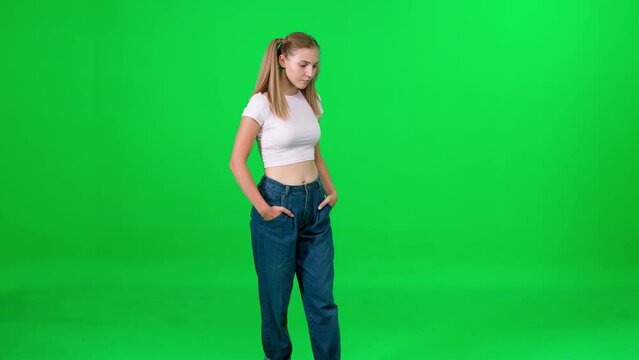 Young female walking down the street on a green background, a passerby on a walk, chroma key template, young woman in a white t-shirt and blue jeans, citizen.