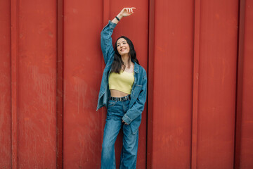 young girl in jeans posing at the wall