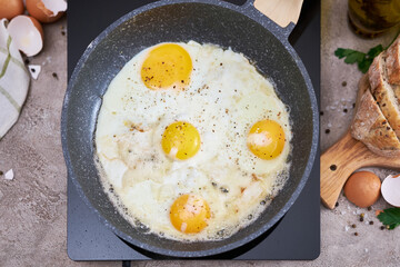Fried Egg in cast iron frying pan on black induction hob