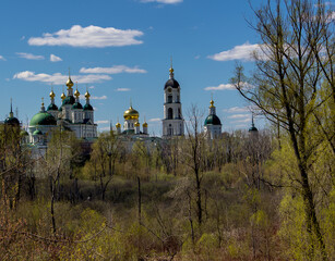 Orthodox complex of buildings in spring among trees and bushes.