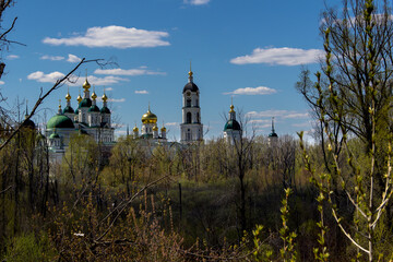 Orthodox complex of buildings in spring among trees and bushes.