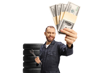 Car mechanic in a uniform holding a wrench and money banknotes