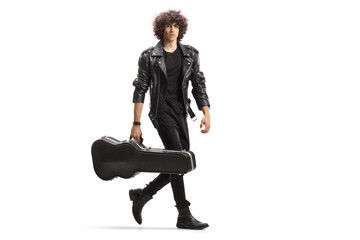 Full length portrait of a young rock musician carrying a guitar in a black case