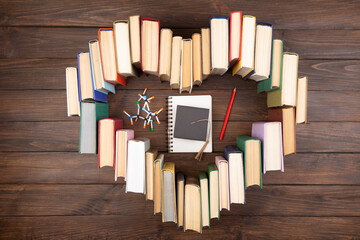 Love science concept. Heart shape of books, graduate cap and molecule model on wooden desk. Take a degree in natural Sciences!