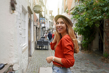 Portrait of smiling traveler woman in Schnoor neighborhood, Bremen, Germany - obrazy, fototapety, plakaty