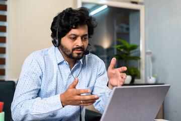 Corporate employee busy attanding meeting by advising on laptop at office - concept of customer...