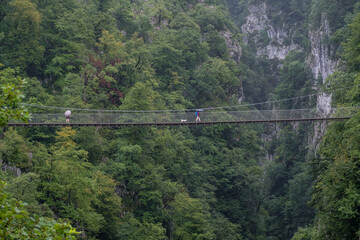 senderistas con paraguas sobre la pasarela d’Holtzarte,  gargantas de Holzarté, Larrau, región de Aquitania, departamento de Pirineos Atlánticos, Francia