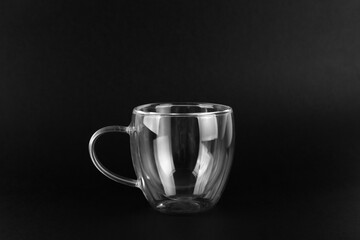 Empty double wall glass cup mug isolated on a black background