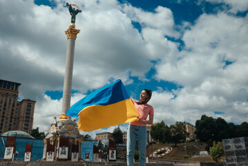 Young woman with national flag of Ukraine on the street