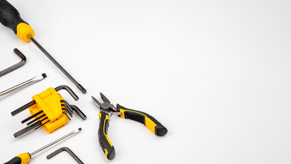 DIY Tool For Building Or Repairing On White Background. The Workplace Of The Foreman. Professional Repair And Construction Tool. Space For Text. Screwdriver, interchangeable nozzles, wrench, pliers.