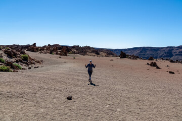 Front view of hiking woman with scenic view on moon desert landscape of Minas de San Jose Sur near volcano Pico del Teide, Mount El Teide National Park, Tenerife, Canary Islands, Spain, Europe. Awe