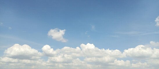 Fototapeta na wymiar white clouds clumping up in the bright blue sky.