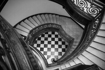 High angle above view down of old vintage staircase winding spiral. Spiral staircase with chess...