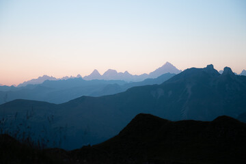 Obraz premium First sunlight on the mountains of the Lac de Peyre in French Alps. Mountain layers at sunrise