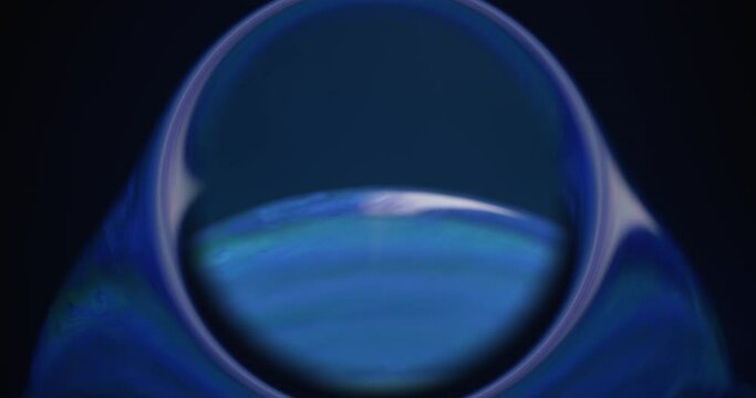 Oil water sphere. Round frame. Soap bubble. Iridescent reflection. Purple blue color clear circle globe on dark abstract background shot on RED Cinema camera.