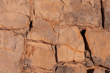 Stone texture background. Stone wall is sand colored with natural scratches and stains.