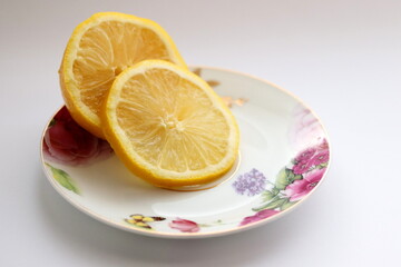 Lemon on plate. Sliced lemon isolated on white background, close up.