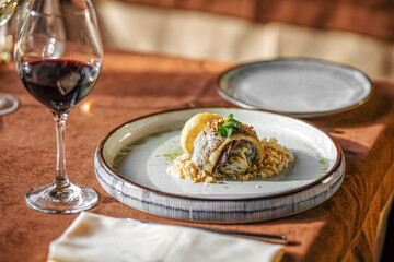 Gourmet restaurant fish dish with couscous and red wine