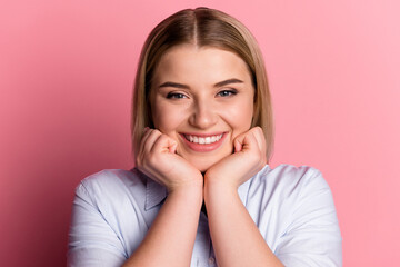 Photo of young pretty cheerful woman hands touch cheeks dream think idea isolated over pink color background