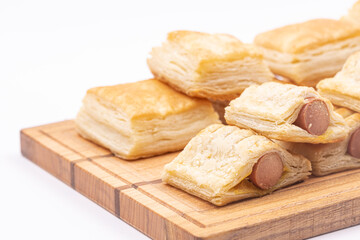 Puff pastry on the serving wooden board isolated above white background