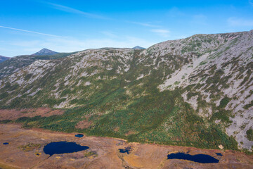 Aerial view of the lakes near the foot of the mountain. View of the swampy shore of the lake and...