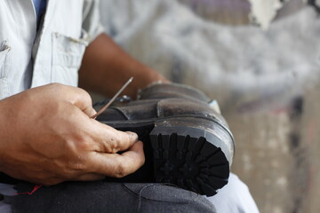 Repairing broken shoes by a shoe repairman. Mark the bottom of the shoe to be sewn using the shoe sole line tool.