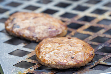 Burger patties grilled. Two patties of ground meat on a cooking grate, bbq