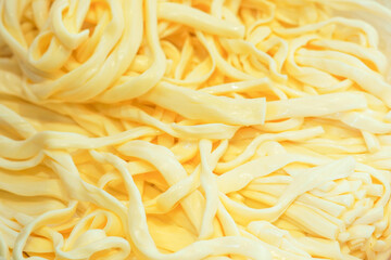 Chechil or chechili is an Armenian brined string cheese and is produced in the form of dense strings. Soft, creamy chechil close-up background. Texture of cheese chechil