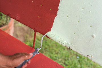 Applying a layer of light green colored quick dry enamel paint on top of another red oxide primer...
