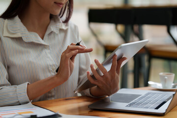 Close up Business woman hand using calculator app on tablet to calculate the company's financial results and budget. Account Audit Concept.