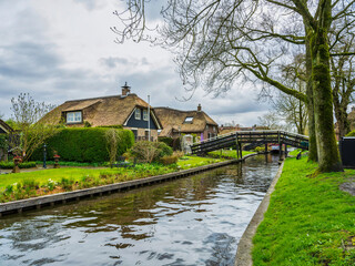 Fototapeta na wymiar Dutch house and wodden bridge in the charming village of Giethoorn, Netherlands