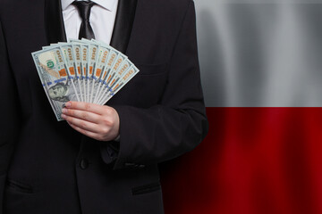 Polish business man with 100 US dollar bills money banknotes against flag of Poland background