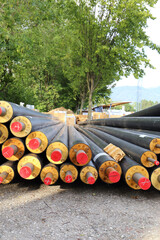 Different dimensions of heating pipes laying near a construction site. Sustainable energy concept.
