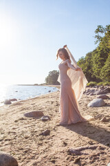 Beautiful woman in red fluttering dress on nature background