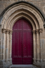 Close-up on Closed red arched church door in rural Aude region, south of France.