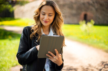 Portrait of young beautiful smiling woman with tablet pc, outdoors