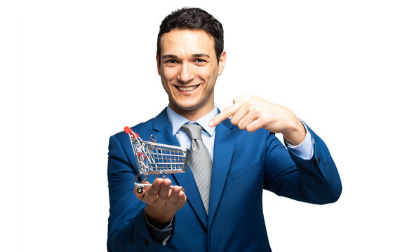 Smiling businessman holding a mini shopping cart