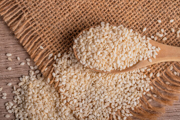 white sesame in wooden spoon on old wooden background