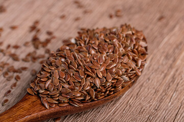 Flax seeds in a wooden spoon. Healthy whole grain food.