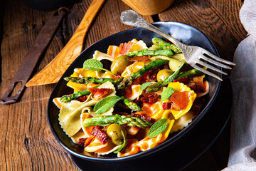 Pasta salad with green asparagus, olives and parma ham