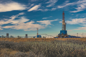 The spring landscape of the Arctic tundra against the background of infrastructure for drilling...