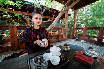 Young woman holding a small bowl of green herbal tea